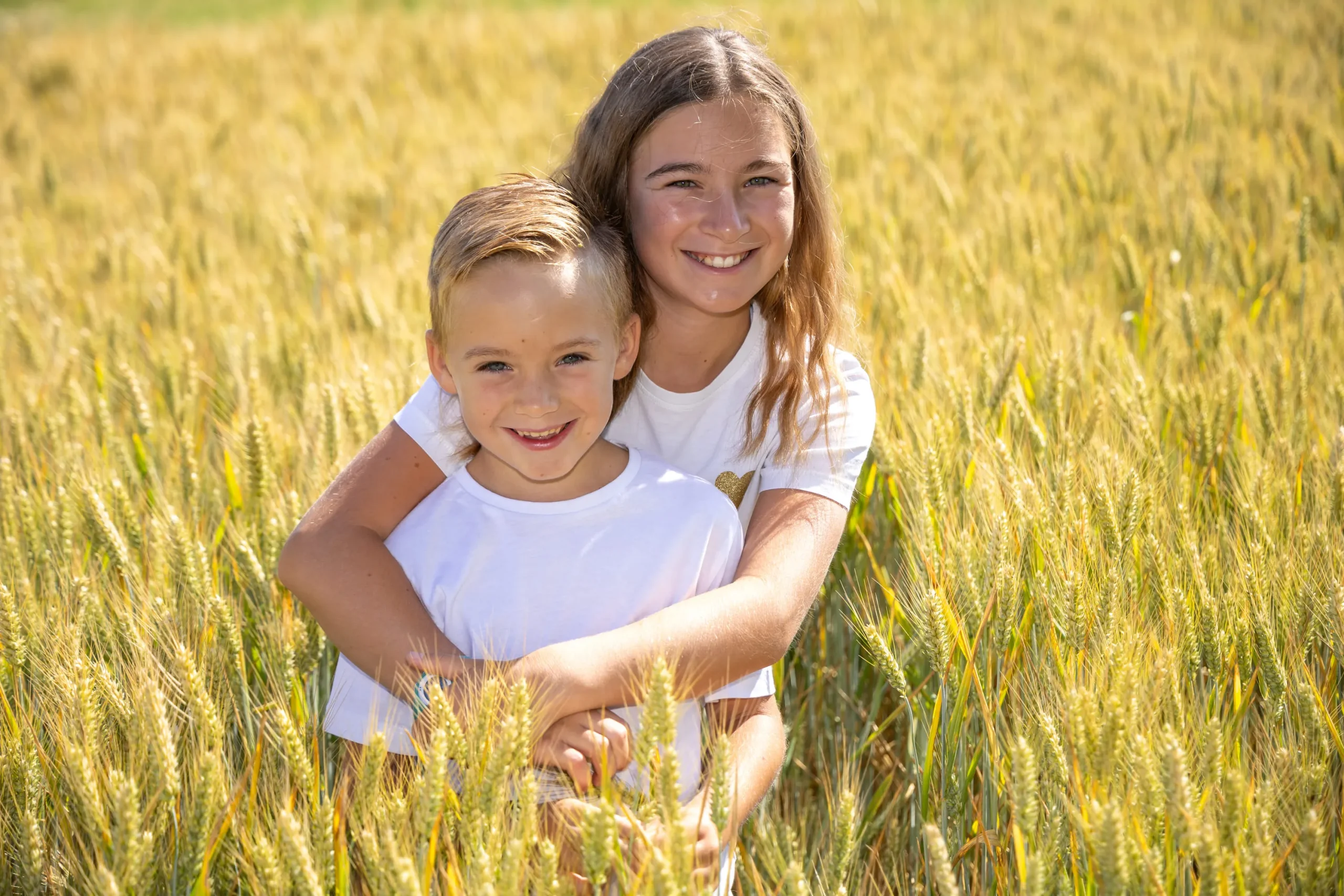 Portrait de deux enfants dans un champs de blé